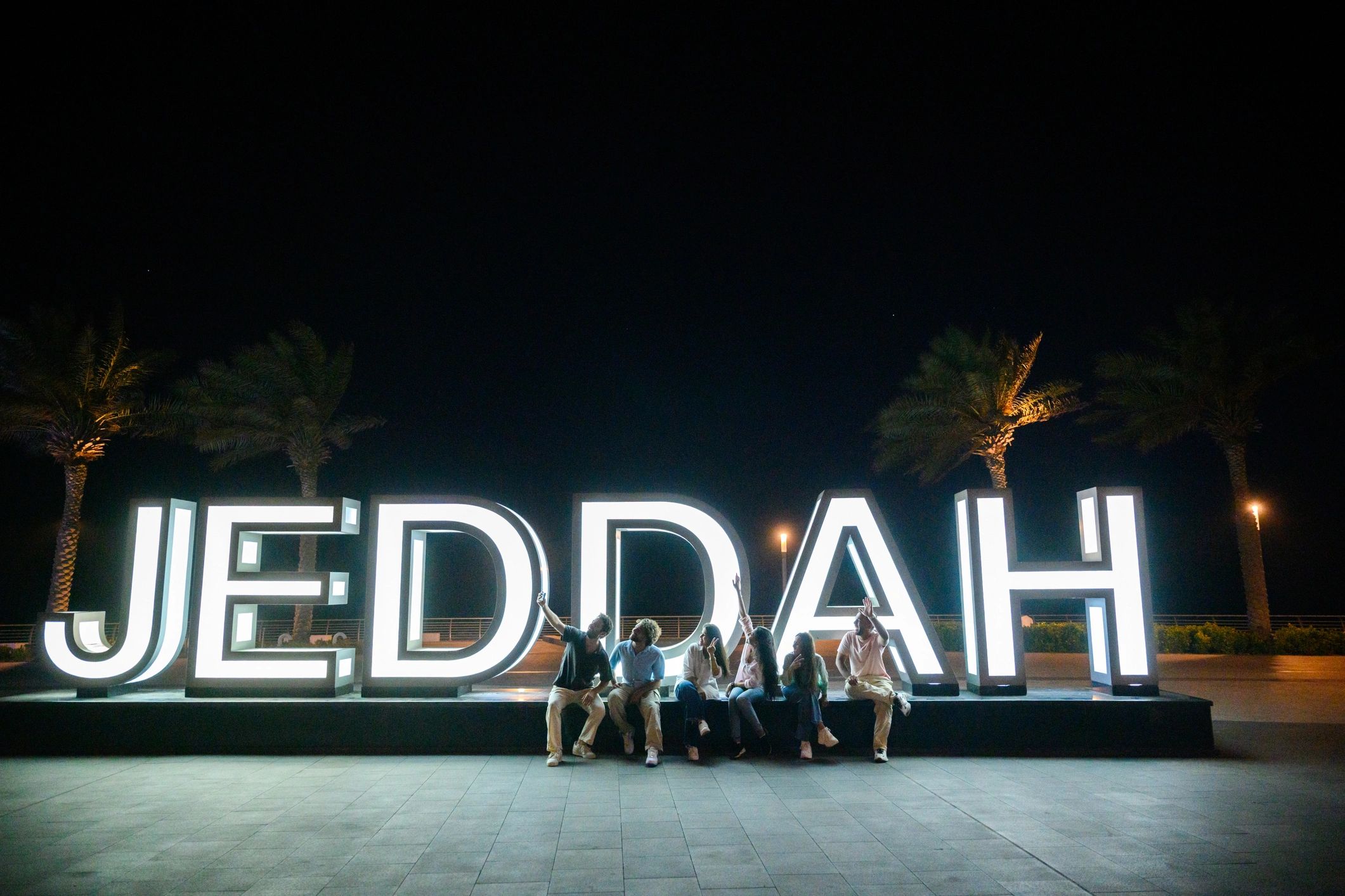 Friends gathering at a city landmark at night